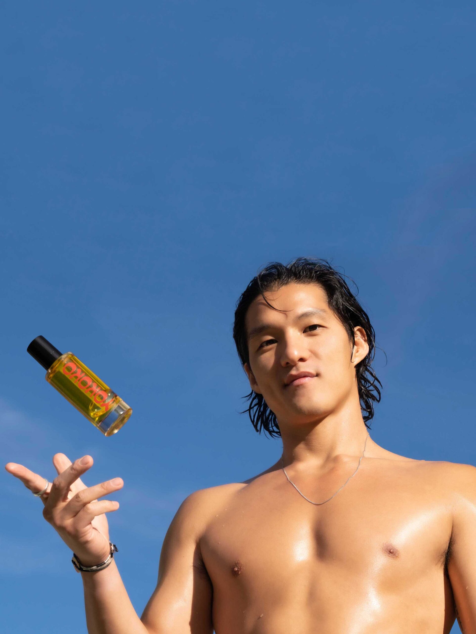 man holding yokoko body oil bottle